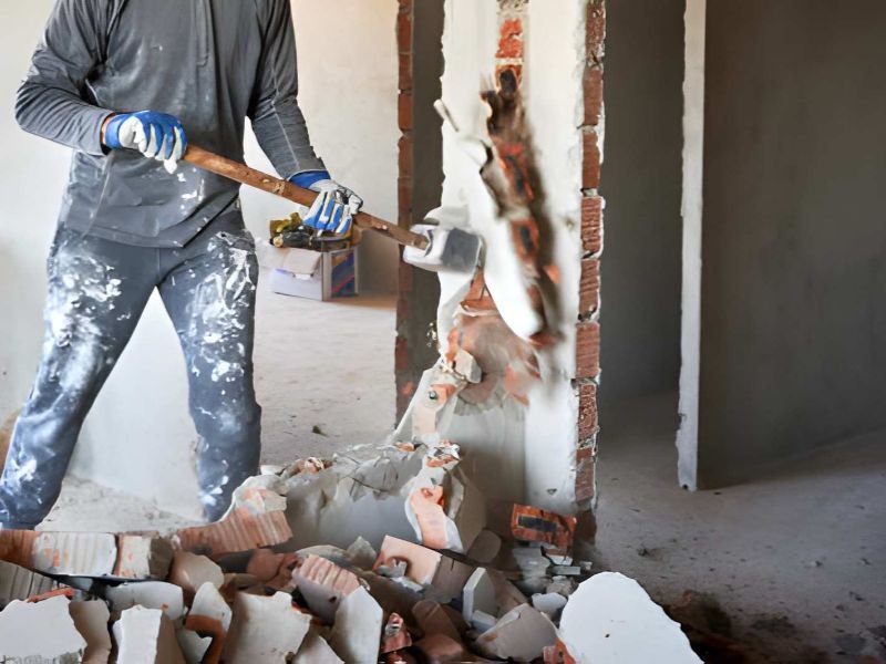 Cropped view dismantler crashing interroom septum with hand's large hammer