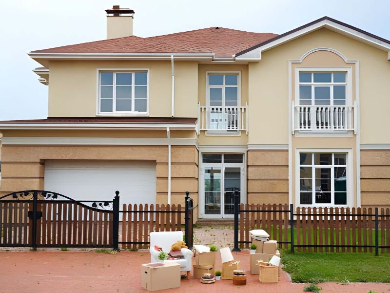 A house with furniture and boxes outside.