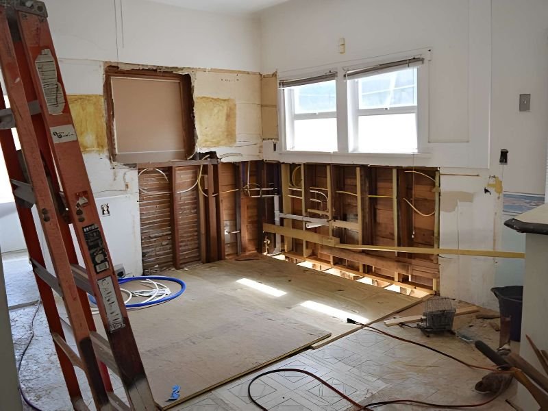A room under renovation with walls and cabinets removed.