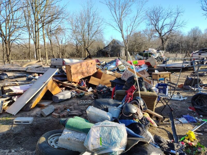 A large pile of discarded items and debris outdoors.