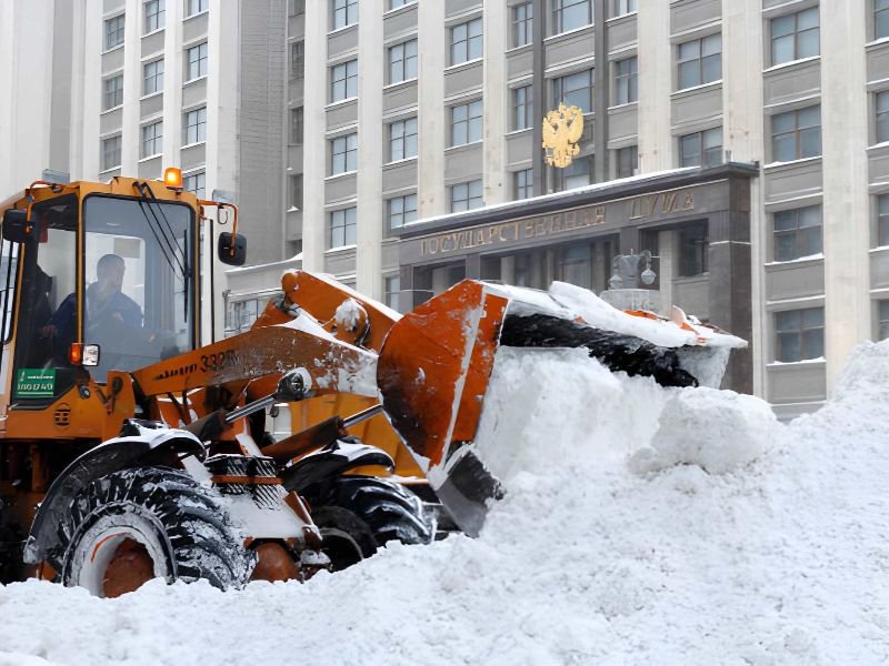 A loader clearing snow in front of a building.