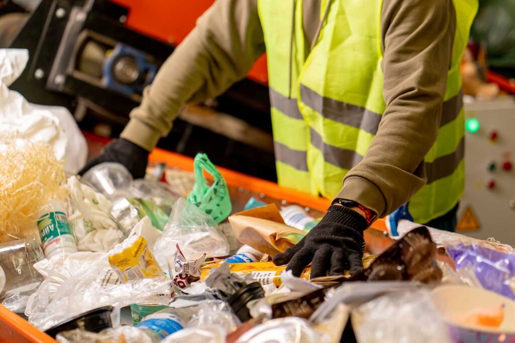 hands-in-gloves-of-employee-sort-garbage-into-cate