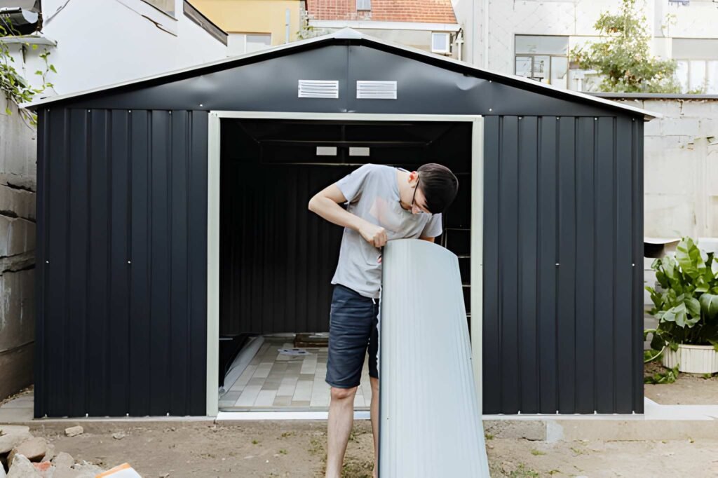 A young brunette man removes a protective film from a metal surface.