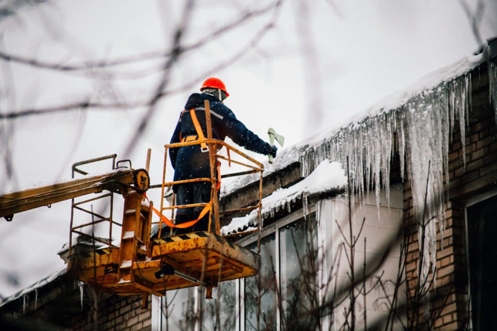 a-utility-worker-knocks-down-huge-icicles-