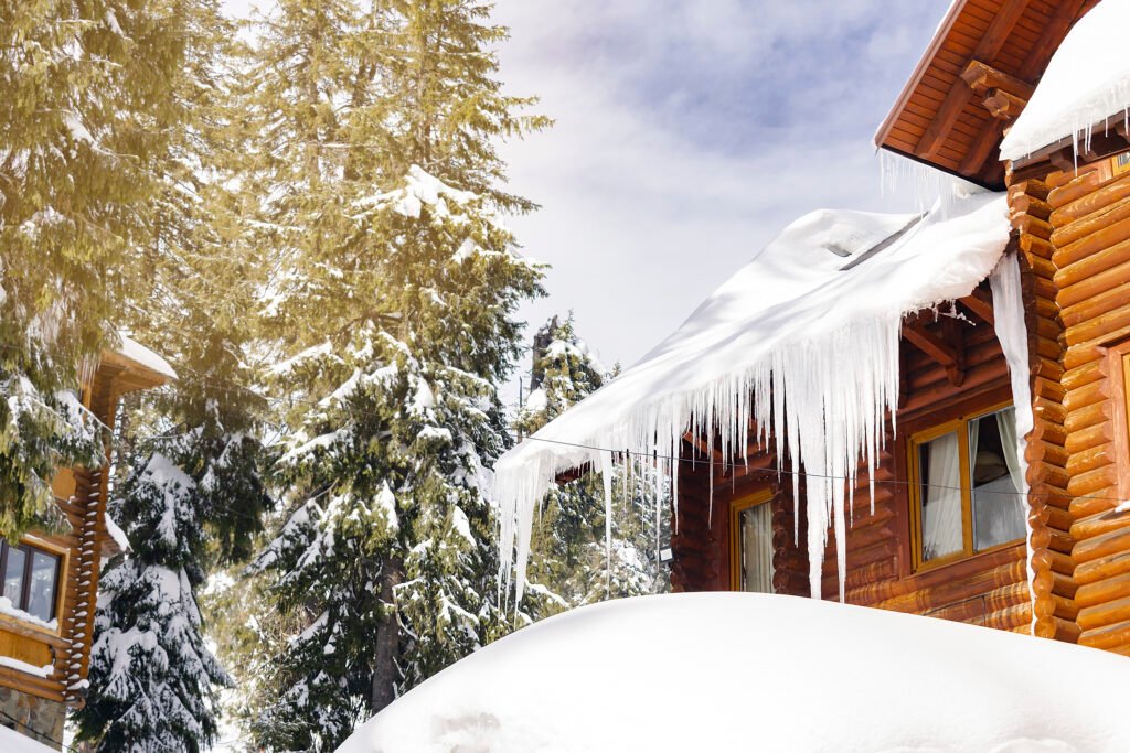 Wooden village rural house,mansion,hotel covered in snow,icicles in winter forest mountains